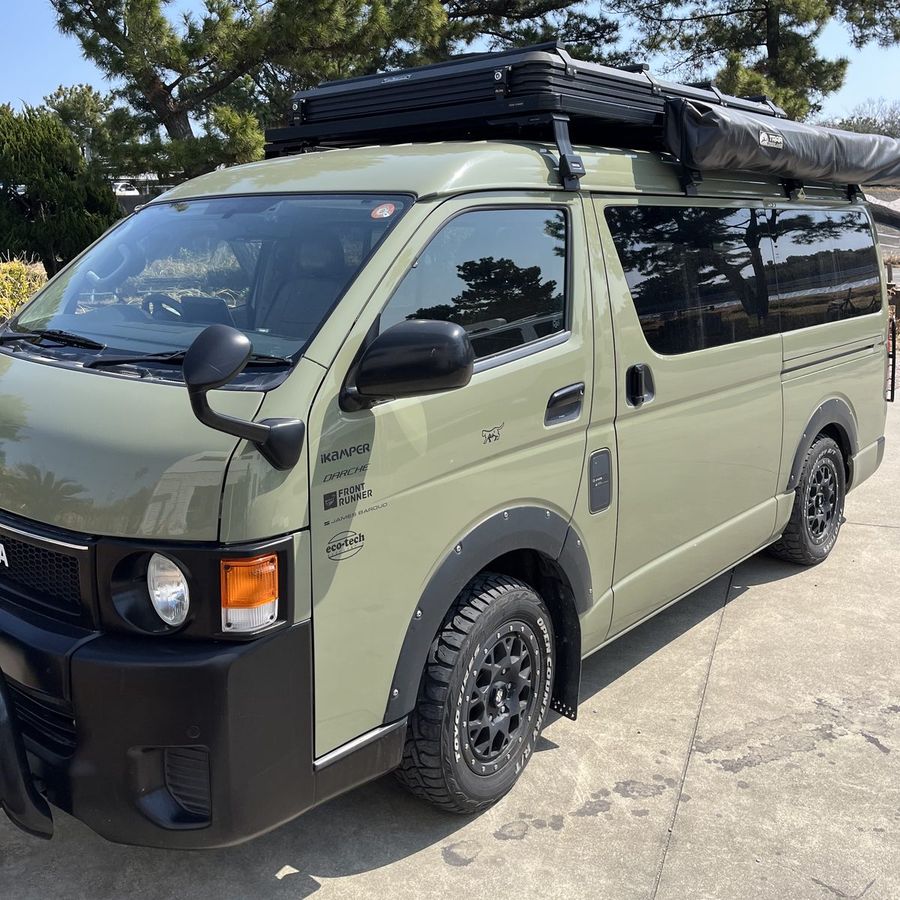 ルーフテントとオーニングを載せたカーキ色のハイエース